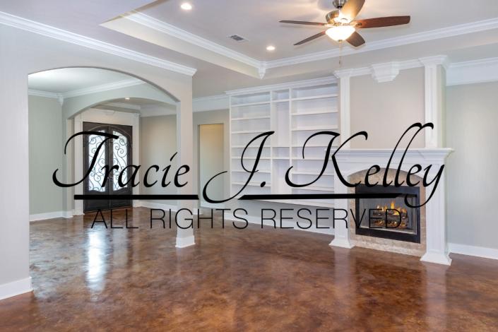 This view features a view from the living room looking towards the front entrance & dining area. It features bookcases & a fireplace.